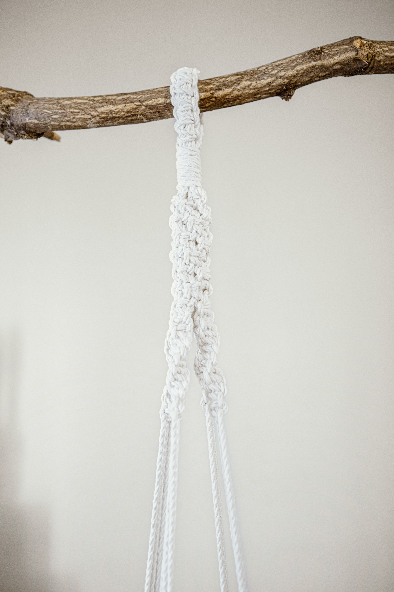 Detalle superior de macetero artesanal de macramé fabricado en algodón ecológico en color crudo